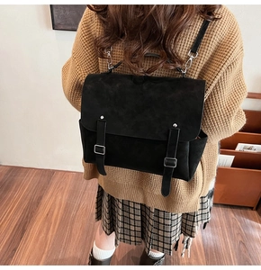 Close-up of black matte vintage backpack showing texture and silver buckles detail