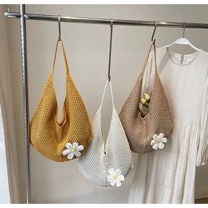 Dettaglio dei sacchetti di paglia intrecciati in giallo e beige con decorazione a margherita