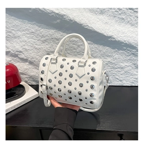 Detail of white Boston bag with silver studs and polished finish in handheld view