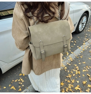 Outdoor view of a vintage faux leather backpack in khaki showing side pocket and matte texture