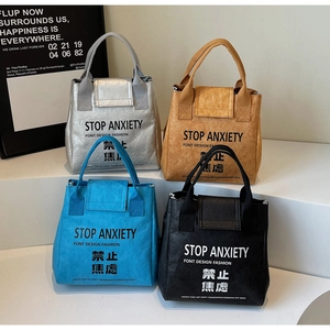 Close-up of waterproof Dupont paper tote bags in four colors with Stop Anxiety print