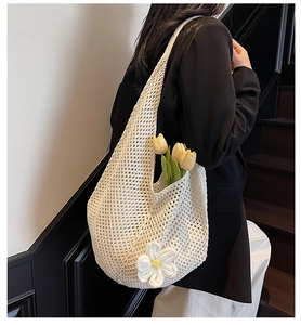 Dettaglio della borsa tote all'uncinetto bianco crema con fiore 3D e trama a rete