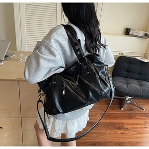 Dettaglio della borsa grande in pelle PU nera con zip metalliche e tracolla regolabile