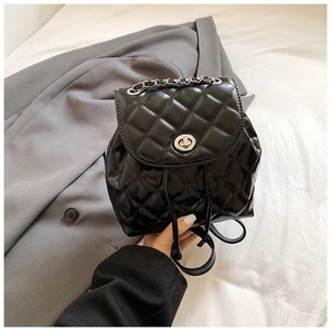 Detail of black quilted leather backpack with silver turn-lock and chain handle
