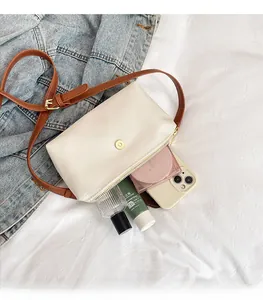 Detail view of the spacious inner compartment of the cream nylon crossbody bag