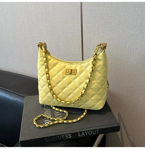 Detailed view of the yellow quilted leather shoulder bag with a metal twist lock closure