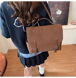 Detail view of large brown retro backpack with sturdy top handle and parallel buckles