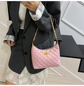 Detail of pink quilted hobo bag featuring gold chain strap and metal twist lock