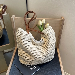 Detail of woven tote bag featuring hollow mesh texture and brown leather straps