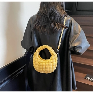 Détail du sac croissant jaune matelassé avec motif à carreaux et bandoulière réglable