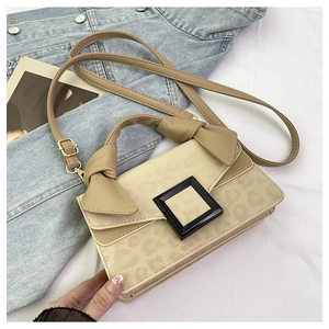 Detail view of leopard print flap on beige crossbody bag with large black square buckle