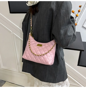 Detail of pink quilted shoulder bag with gold twist lock and leather chain strap