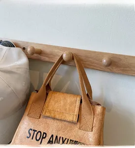 Detail of Tyvek tote bag featuring a black Stop Anxiety slogan and a webbed handle