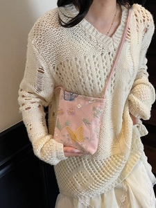Pink crossbody phone bag with floral butterfly embroidery worn by a model in a sweet style