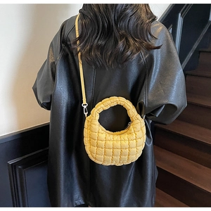 Sac à bandoulière matelassé jaune en coton avec manteau cuir noir en vue détaillée