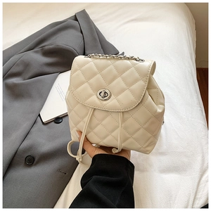 Detail of quilted beige leather backpack with chain handle and silver twist lock