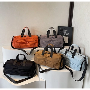 Five assorted colors of large travel bags with pleated design on white display stands