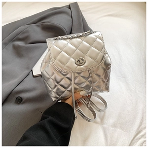 Silver quilted mini backpack detail featuring metallic leather and chain strap textures