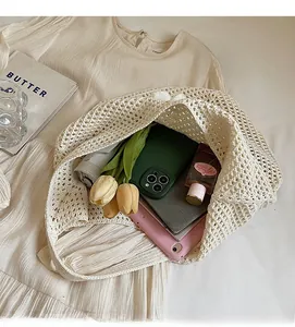 Dettaglio della grande borsa tote intrecciata beige piena di oggetti per la spiaggia e relax