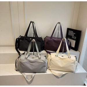 Detailansicht der Reisetaschen in Schwarz, Lila, Grau und Creme mit gewebter Textur