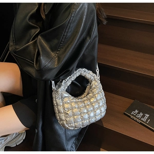 Détail du sac matelassé argenté avec texture métallique et bandoulière à chaîne blanche