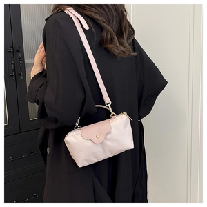 Pale pink nylon crossbody bag shown from the back to display size and fit on a person
