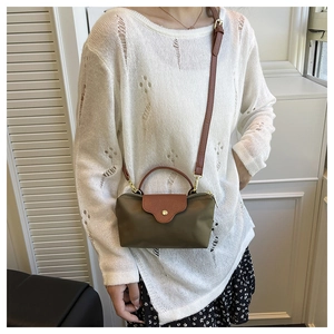 Olive nylon crossbody bag with leather flap and handle shown on a model