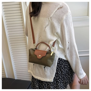 Rear view of a model wearing the olive nylon mini crossbody bag with leather trim