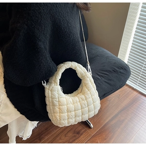 Vue détaillée d'un sac matelassé blanc avec texture bulle et bandoulière longue et fine