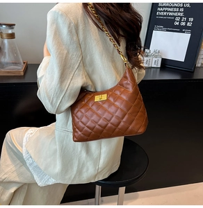 Detail of classic diamond quilted texture and golden turn-lock closure on brown bag