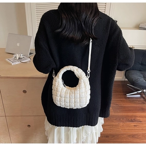 Vue détaillée d'un sac matelassé blanc avec une texture nuageuse douce et sa bandoulière