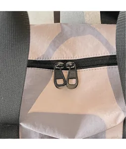 Detail of smooth double metal zippers on water-resistant fabric with geometric pattern