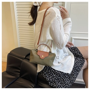 Detail view of mini nylon crossbody bag with leather trim on model in casual setting