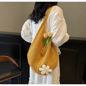 Dettaglio borsa a spalla gialla lavorata a mano con decorazione floreale di margherita