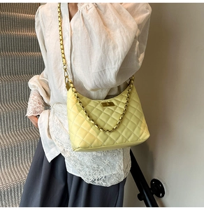 Close-up of cream yellow hobo bag featuring quilted diamond pattern and gold hardware