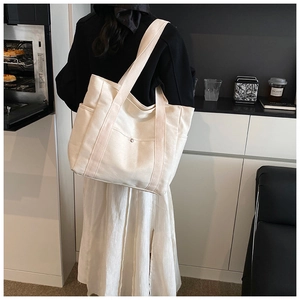 Minimalistische cremefarbene Canvas-Einkaufstasche mit mehreren Taschen in einer modernen Küche