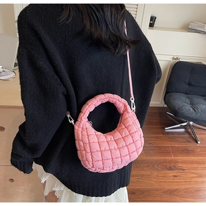 Détail du sac matelassé rose brillant avec bandoulière réglable et texture gonflée