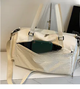 Makrodetail der beigen wasserdichten Nylon-Reisetasche mit silbernem Reißverschluss und Gurt