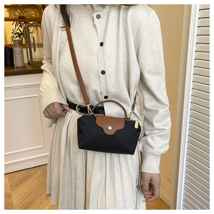 Mini nylon cross-body bag with brown leather flap and shoulder strap worn by a model