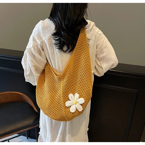 Dettaglio borsa tote gialla all'uncinetto con decorazione floreale a margherita bianca