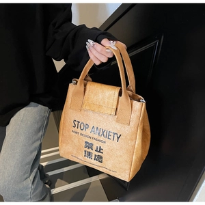 Close-up of yellow waterproof Tyvek bag featuring Stop Anxiety text and unique texture
