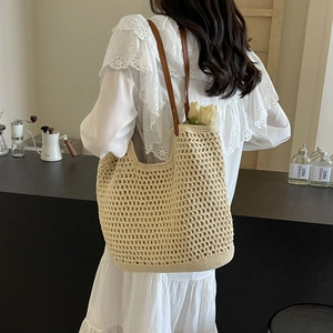 Detail of beige crochet tote bag with mesh texture and brown leather shoulder straps