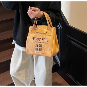 Detailed view of yellow waterproof Tyvek tote bag featuring Stop Anxiety text and texture