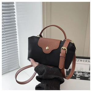 Detail of mini nylon crossbody dumpling bag with leather handle and golden snap button