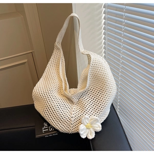 Dettaglio della borsa tote in crochet crema con un grande fiore per vacanze al mare
