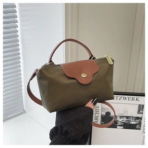 Detail of olive nylon dumpling bag with brown leather flap and golden metal buckle