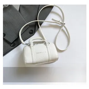 Detailed view of white Boston bag with textured leather and gold-tone zippers