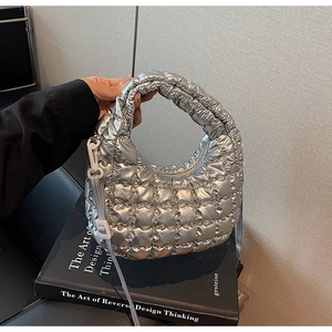 Détail d'un sac à main matelassé argenté avec texture métallique et bandoulière chic