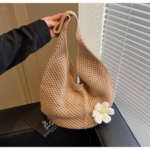Dettaglio della borsa tote beige all'uncinetto con margherite bianche tessute e rete