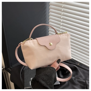 Detail of pink nylon dumpling bag with leather flap and golden snap closure hardware